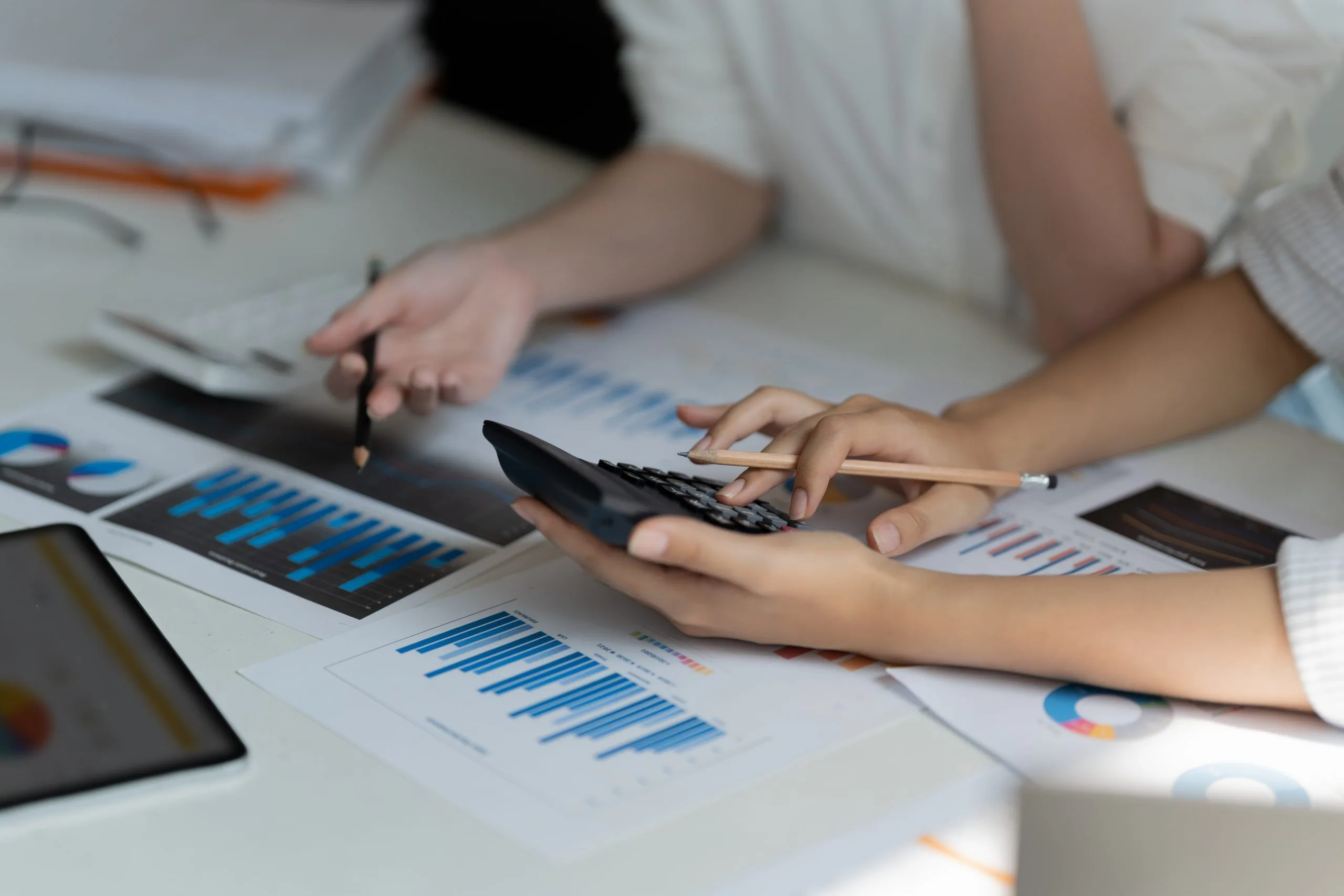Persona usando una calculadora junto a gráficos financieros, imágen del artículo sobre Operación Renta 2025